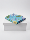 Pantalón largo lino azul claro estampado floral de B&J, posicionado sobre caja.