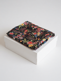 Pantalón largo poliéster negro estampado floral de B&J, posicionado sobre caja.