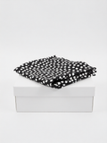 Pantalón largo lino negro estampado lunares de B&J, posicionado sobre caja.