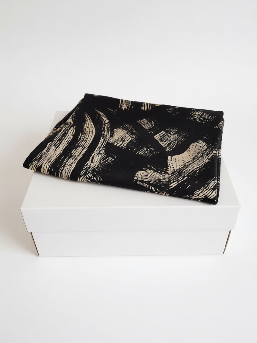 Conjunto mujer seda negro estampado rayas de B&J, posicionado sobre caja.
